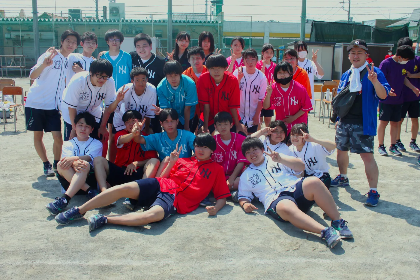 おそろいのクラスTシャツを着て運動会で集合写真におさまる生徒たち