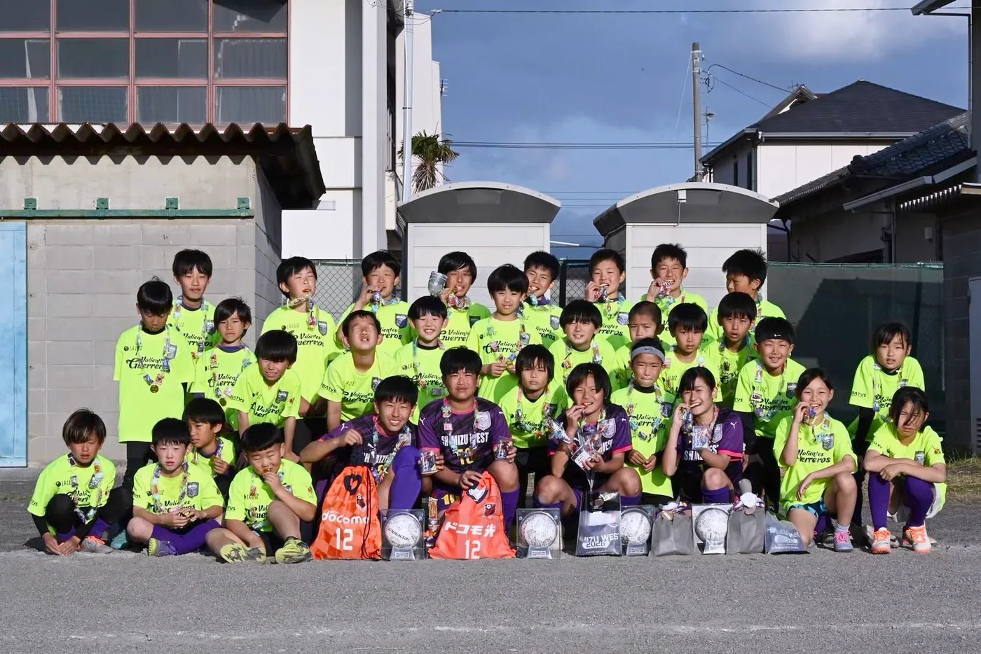 蛍光イエローの練習着を着てグラウンドに集合したサッカー少年団の子どもたち