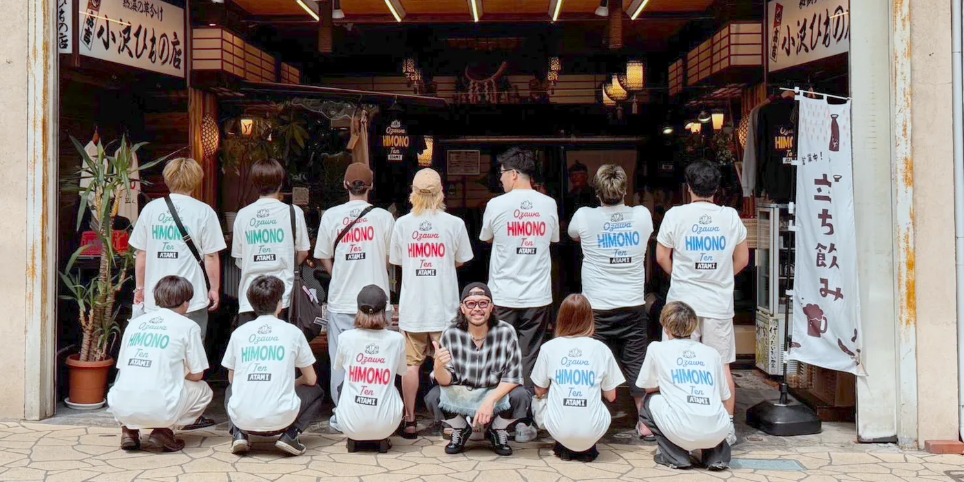 店名入りのオリジナルTシャツを着て店先に並ぶ店舗スタッフ