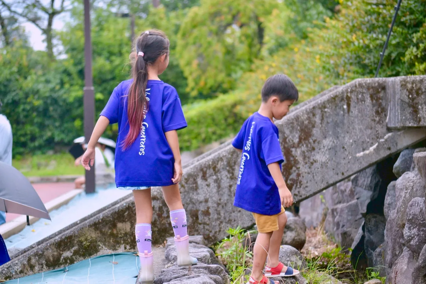 紫の練習着を着た子どもふたりが石段を歩く後ろ姿