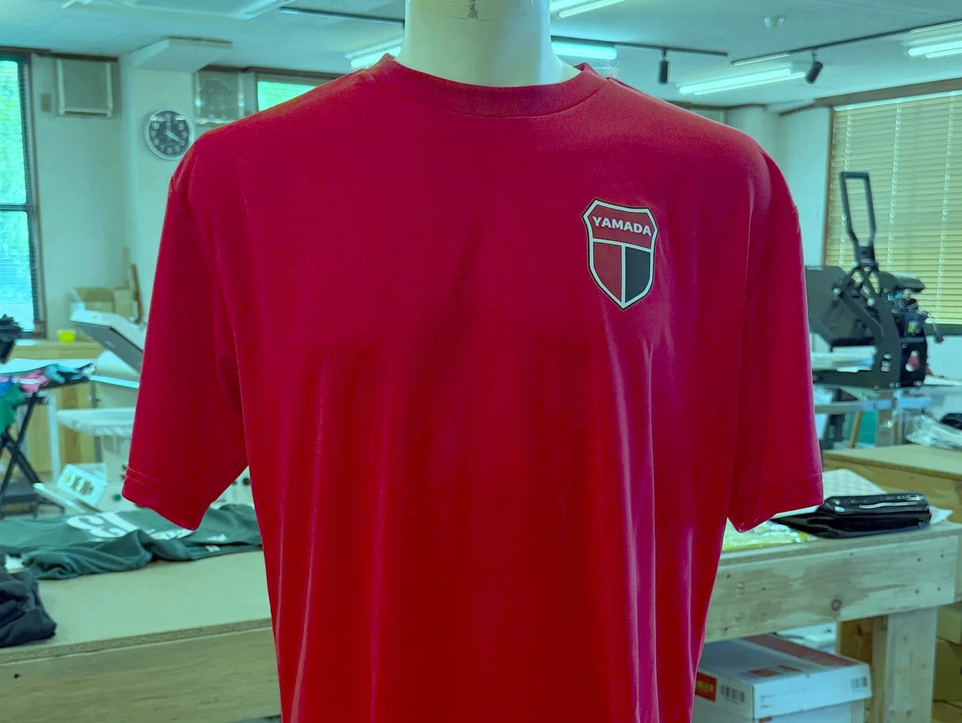 胸にエンブレムを入れた赤のドライTシャツの練習着