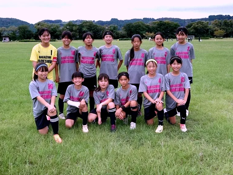 グレーにピンクのチーム名を入れたアウェイユニフォームを着る長泉なでしこFC様の選手たち